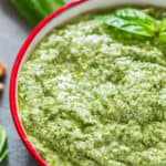 healthy vegan basil walnut pesto in white bowl with text overlay