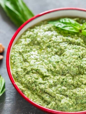 Basil Walnut Pesto in a bowl with wooden spoon