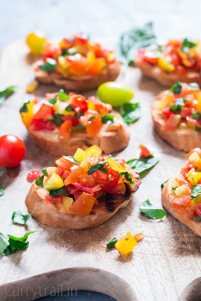 Wooden platter with fresh tomato bruschetta lined up