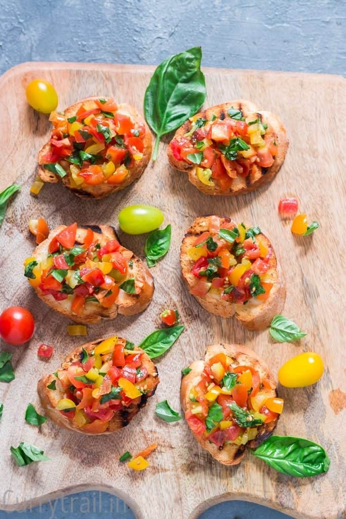 Wooden platter with fresh tomato bruschetta lined up