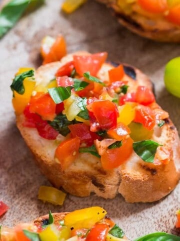 Rainbow colored fresh tomato bruschetta with fresh basil leaf