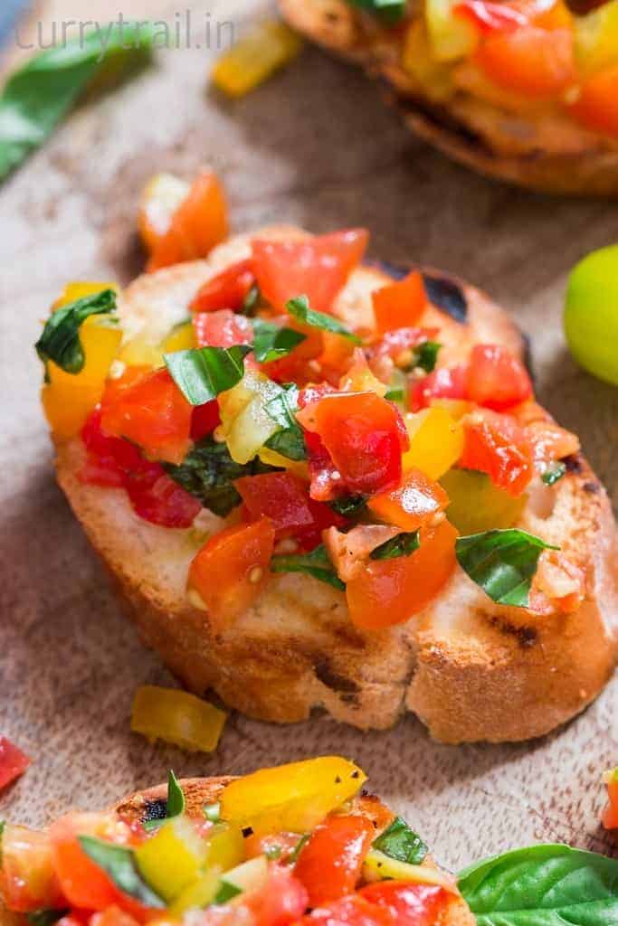 Rainbow colored fresh tomato bruschetta with fresh basil leaf