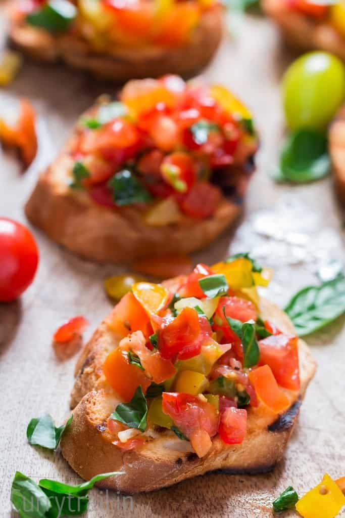 Wooden platter with fresh tomato bruschetta lined up