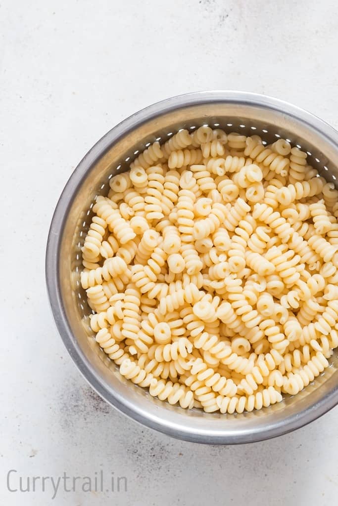 cooked Fusili bucati pasta in a colander 