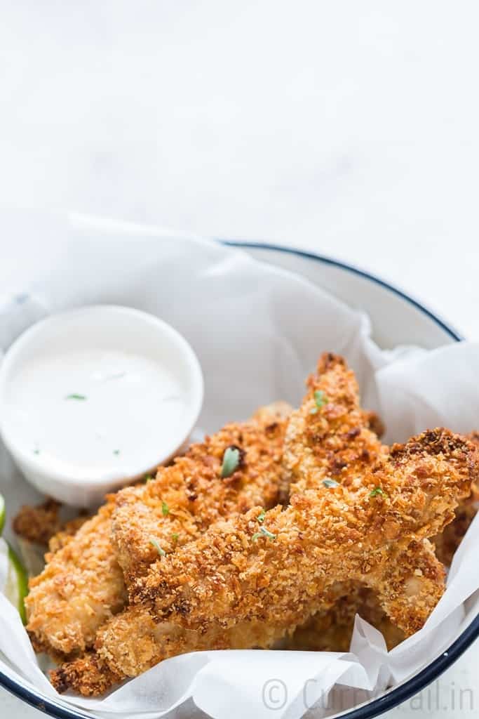 Crispy Parmesan crusted oven baked chicken tenders served on a white plate with ranch dip on sides