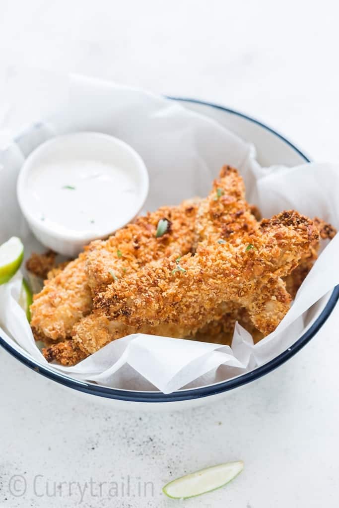 Crispy Parmesan crusted oven baked chicken tenders served on a white plate with ranch dip on sides