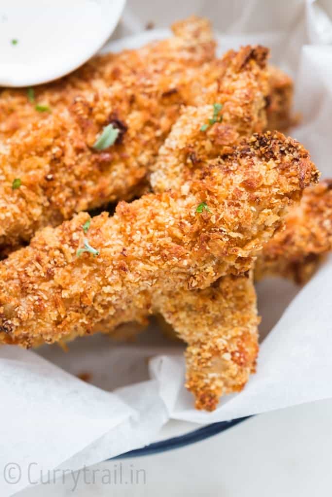 Crispy Parmesan crusted oven baked chicken tenders served on a white plate with ranch dip on sides