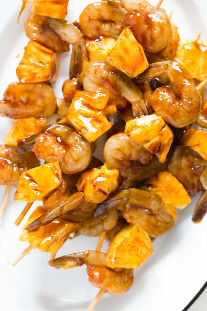 marinated pineapple and shrimp skewers on bamboo stick on white plate