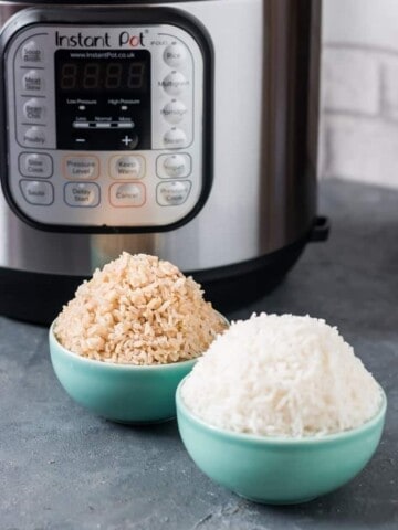 white rice and brown rice served in small green bowls with instan pot behind