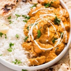 Instant pot butter chicken in white plate with rice and naan
