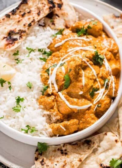 Instant pot butter chicken in white plate with rice and naan