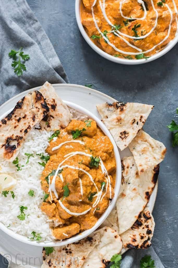 Instant pot butter chicken in white plate with rice and naan