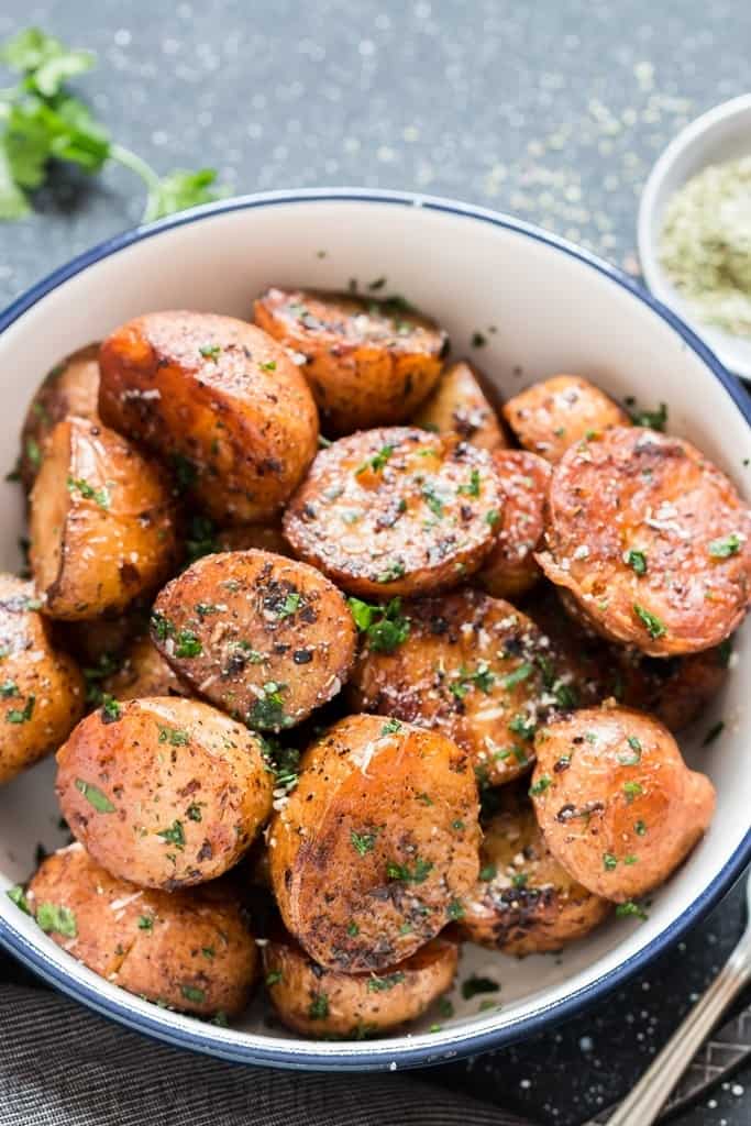 instant pot potatoes roasted with garlic butter and herbs served in white blue rim bowl