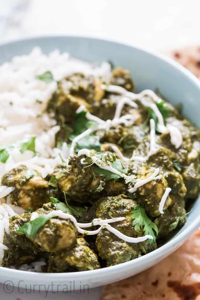instant pot saag chicken with rice in a bowl and rotis on side
