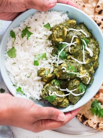 instant pot chicken saag with rice in a bowl and rotis on side