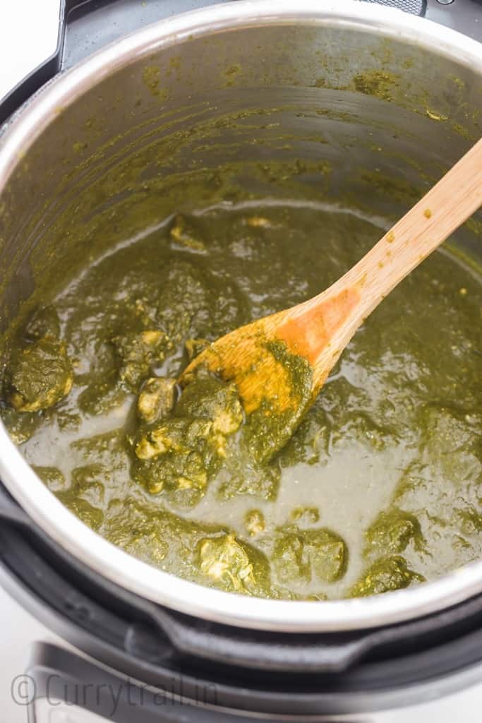 Instant Pot saag chicken with wooden spatula