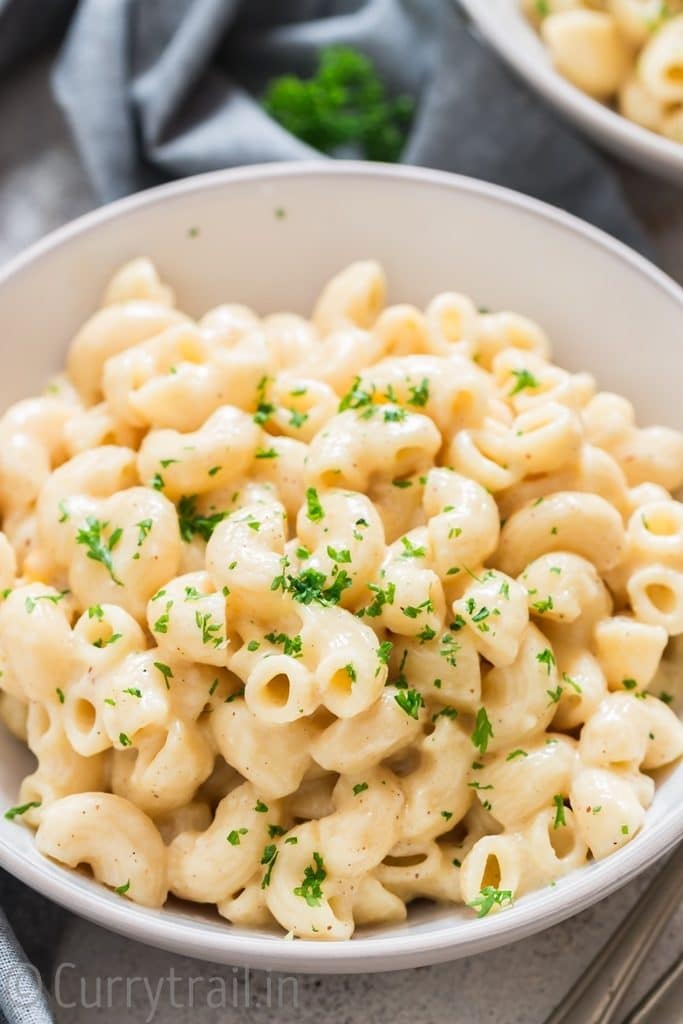 instant pot macaroni and cheese served in white bowls sprinkled with parsley