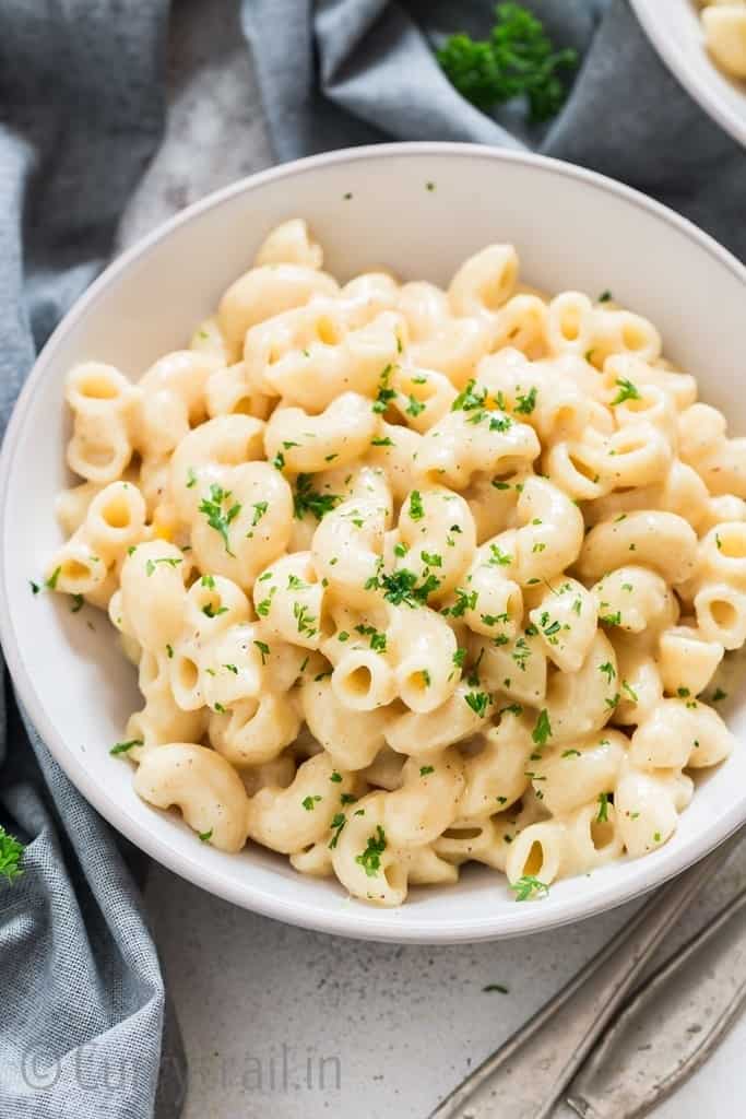 macaroni and cheese in white bowl garnished with parsley