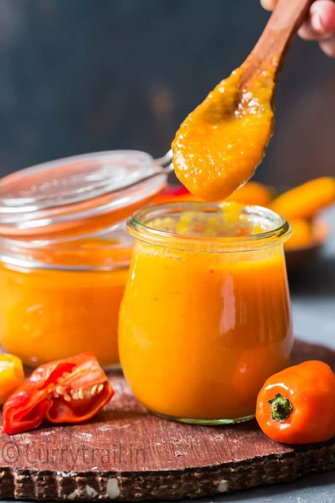 spooning hot sauce from jar