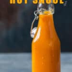 bottle full of spicy hot sauce made of mango and habanero peppers with text