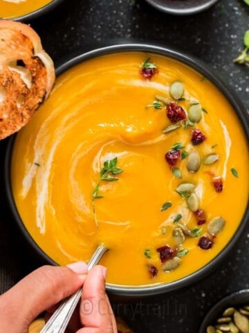 instant pot butternut squash soup served in black bowl with spoon