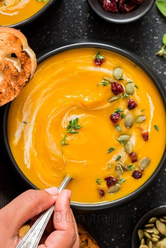 instant pot butternut squash soup served in black bowl with spoon