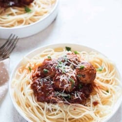 instant pot chicken Parmesan meatballs served on spaghetti in 2 white plates