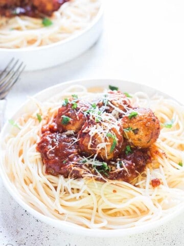 instant pot chicken Parmesan meatballs served on spaghetti in 2 white plates