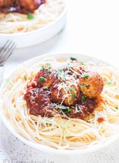 instant pot chicken Parmesan meatballs served on spaghetti in 2 white plates