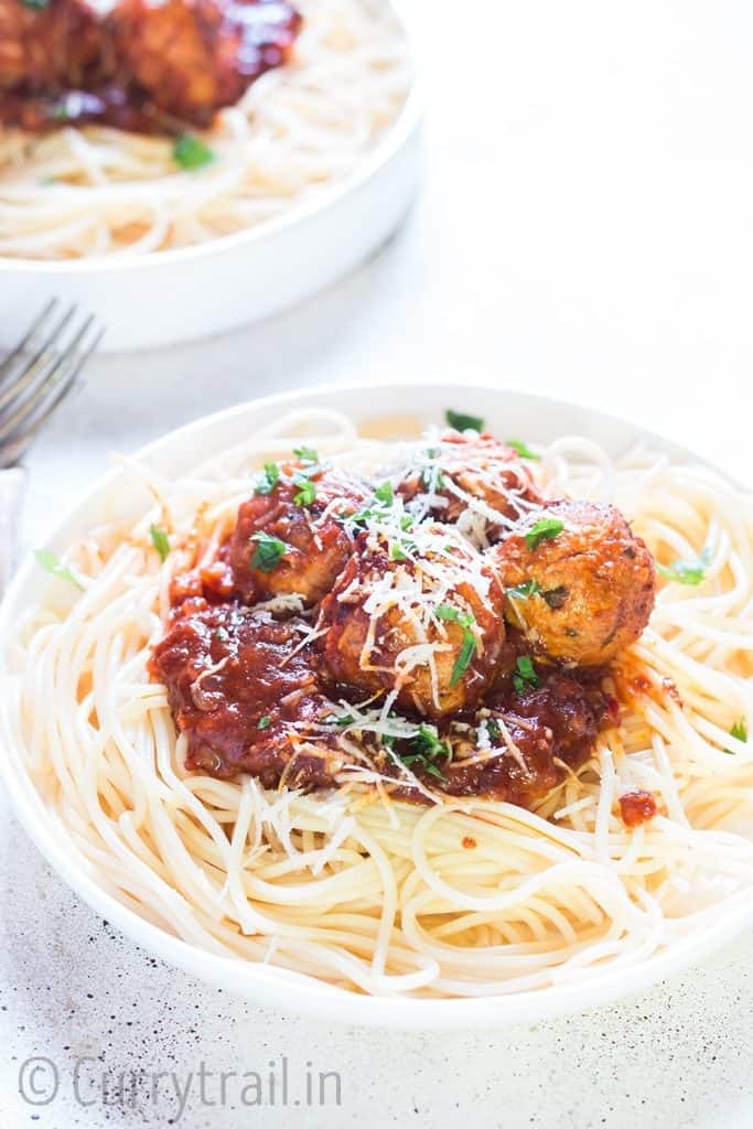 instant pot chicken Parmesan meatballs served on spaghetti in 2 white plates