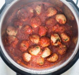 Instant pot chicken Parmesan meatballs cooking in marinara sauce