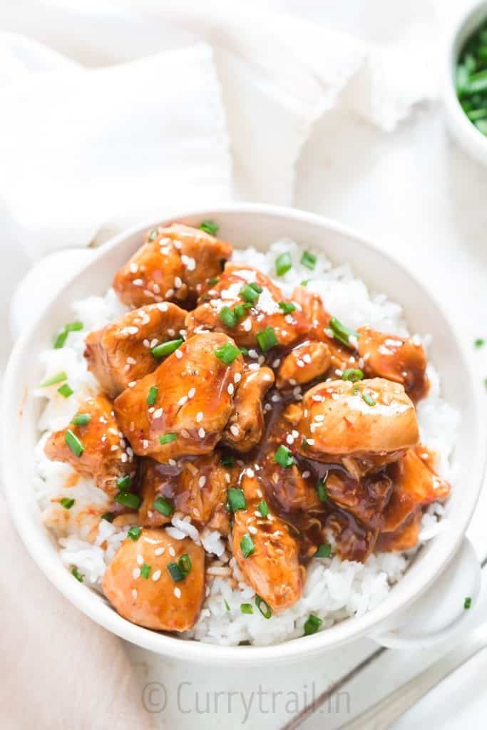 instant pot General Tso chicken in white bowl with chives garnish