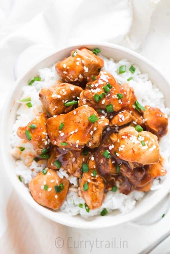 General Tso chicken made in instant pot served over bowl of rice in white bowl