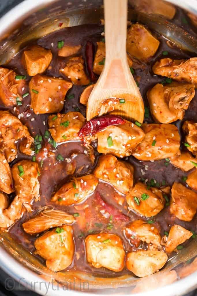 delicious General Tso chicken cooked in instant pot with wooden spatula in it