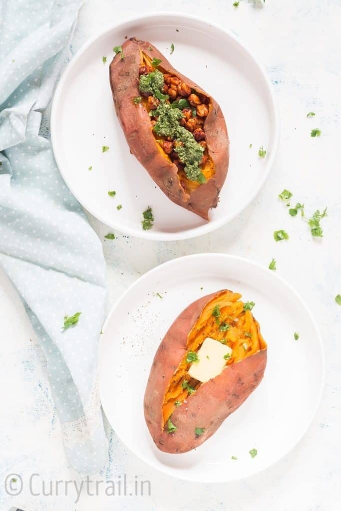 two instant pot sweet potatoes on white plates mashed and stuffed with spicy chickpea filling and cubes of butter