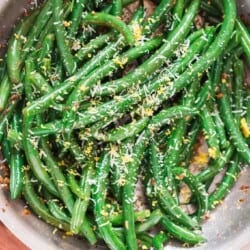garlic sauteed green beans sprinkled with Parmesan and lemon zest Thanksgiving side dish cooked in a skillet,