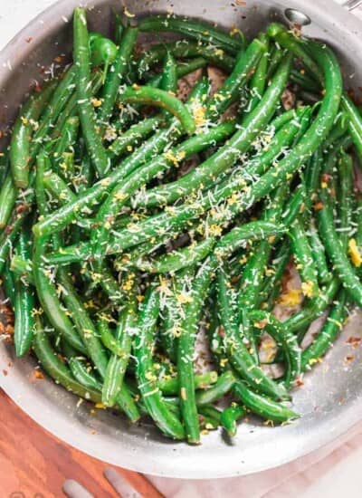 garlic sauteed green beans sprinkled with Parmesan and lemon zest Thanksgiving side dish cooked in skillet