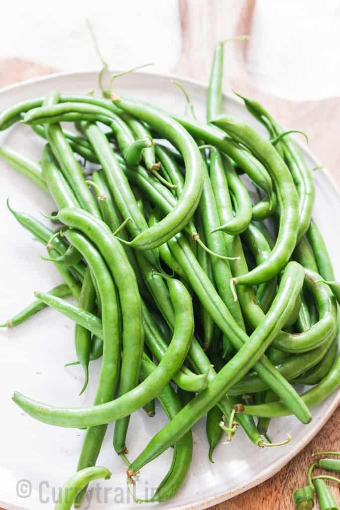 fresh green beans on white plate