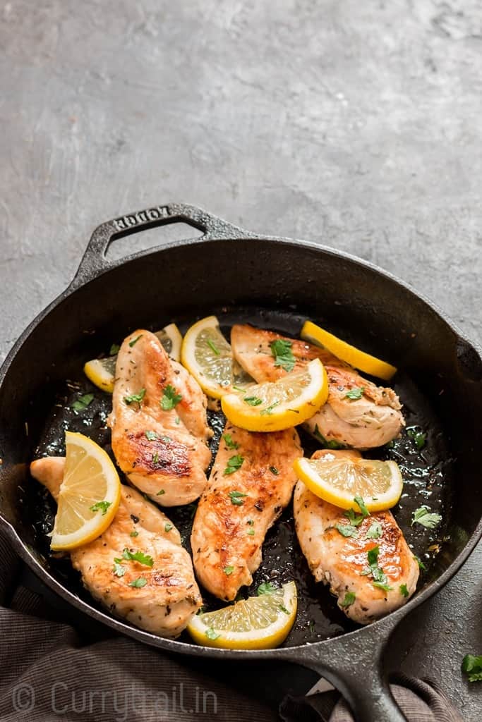 lemon chicken in cast iron skillet with parsley garnish