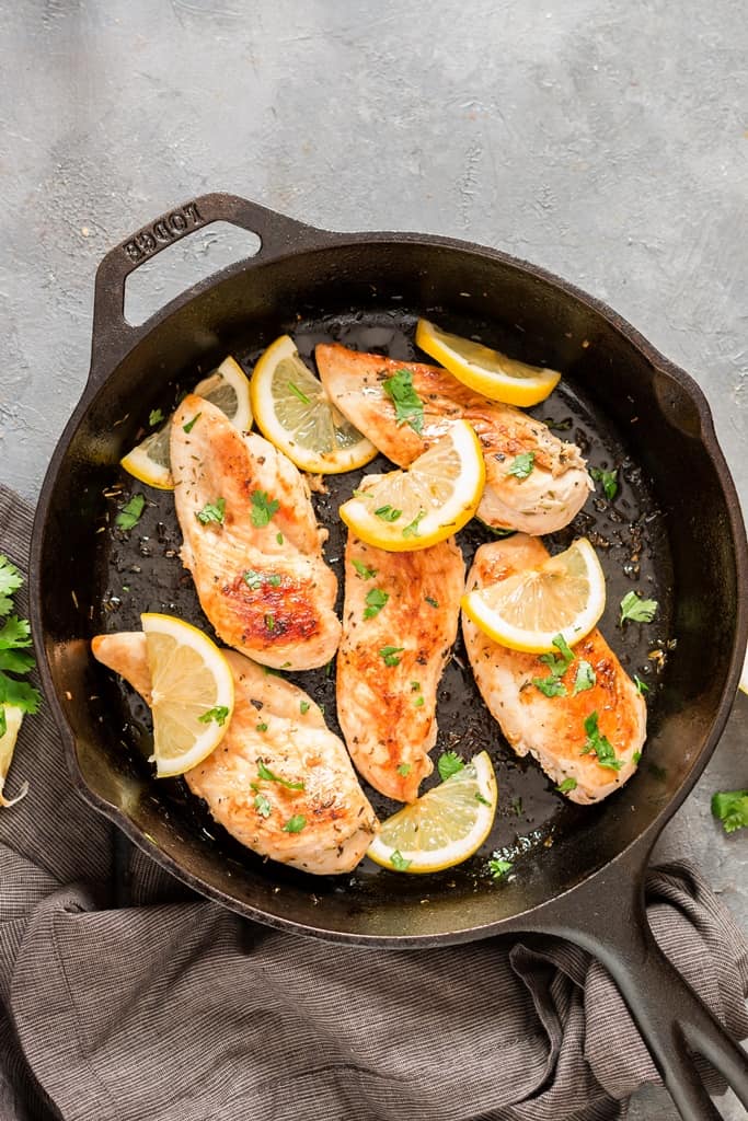 lemon chicken in cast iron skillet with parsley garnish