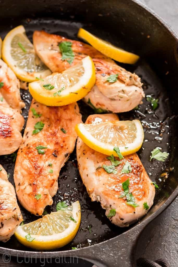 lemon chicken in cast iron skillet with parsley garnish