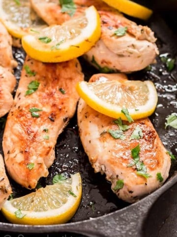 lemon chicken in cast iron skillet with parsley garnish