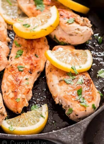 lemon chicken in cast iron skillet with parsley garnish