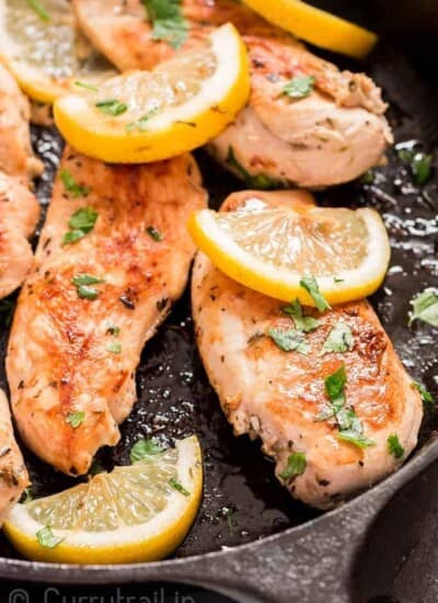 lemon chicken in cast iron skillet with parsley garnish