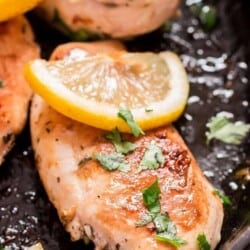 lemon chicken in cast iron skillet with parsley garnish