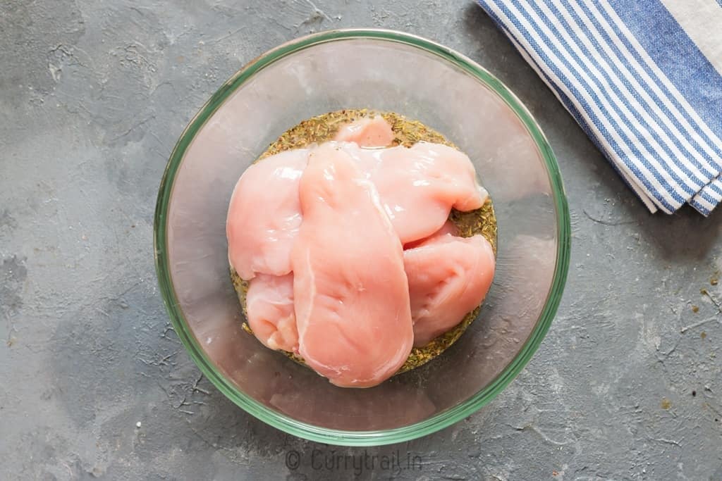 chicken breast marinating in lemon sauce for lemon chicken