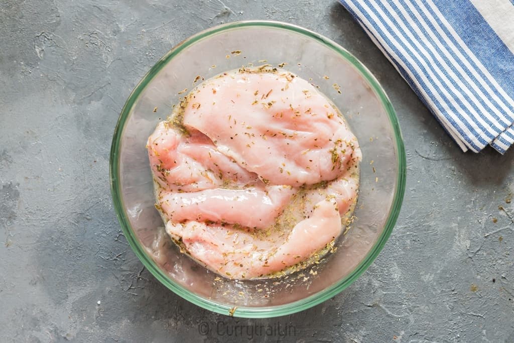 chicken breast marinating in lemon sauce for lemon chicken