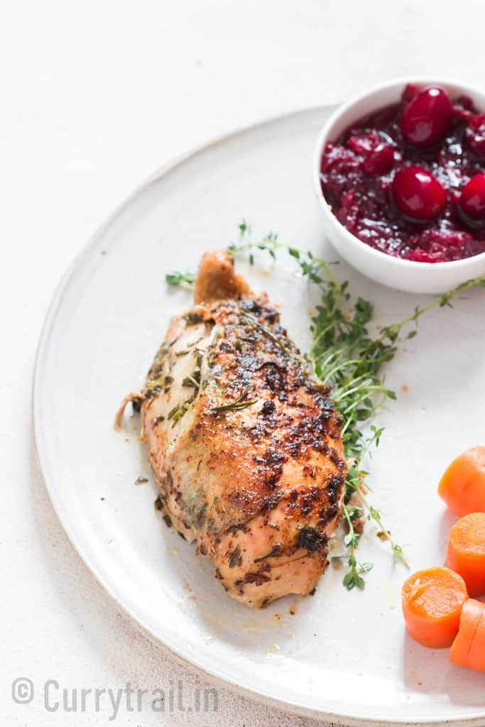 chicken breasts served with vegetable side dishes on a plate.