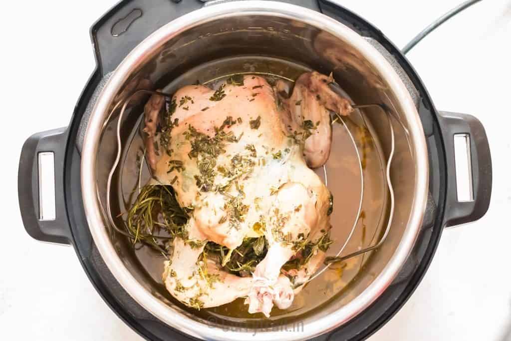 full chicken cooked in an instant pot with chicken broth in it.