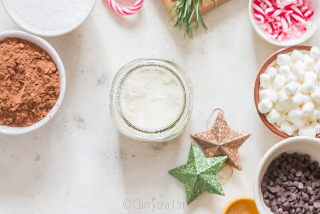 powdered milk is added to a jar for hot chocolate.